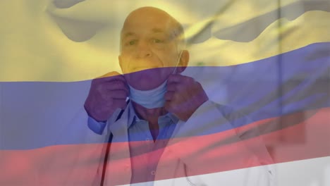 Animation-of-flag-of-colombia-with-male-doctoe-removing-face-mask-and-smiling