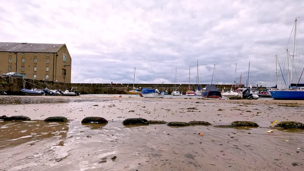 Boats resting on sandy beach during low tide