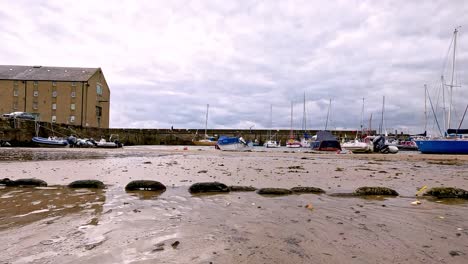 boats resting on sandy beach during low tide