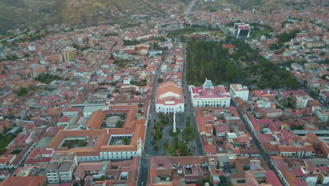 Vista-Aérea-De-Drones-Volando-Hacia-Una-Plaza-En-Sucre,-Bolivia