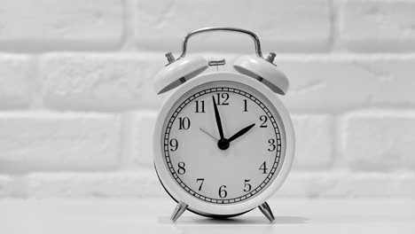reloj de despertador blanco con esfera negra en el fondo de la pared de ladrillo, timelapse