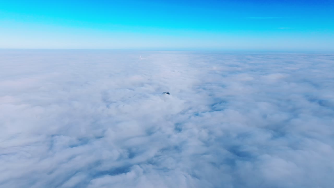 Early morning aerial view above dense fog as Riga skyscraper emerges from mist