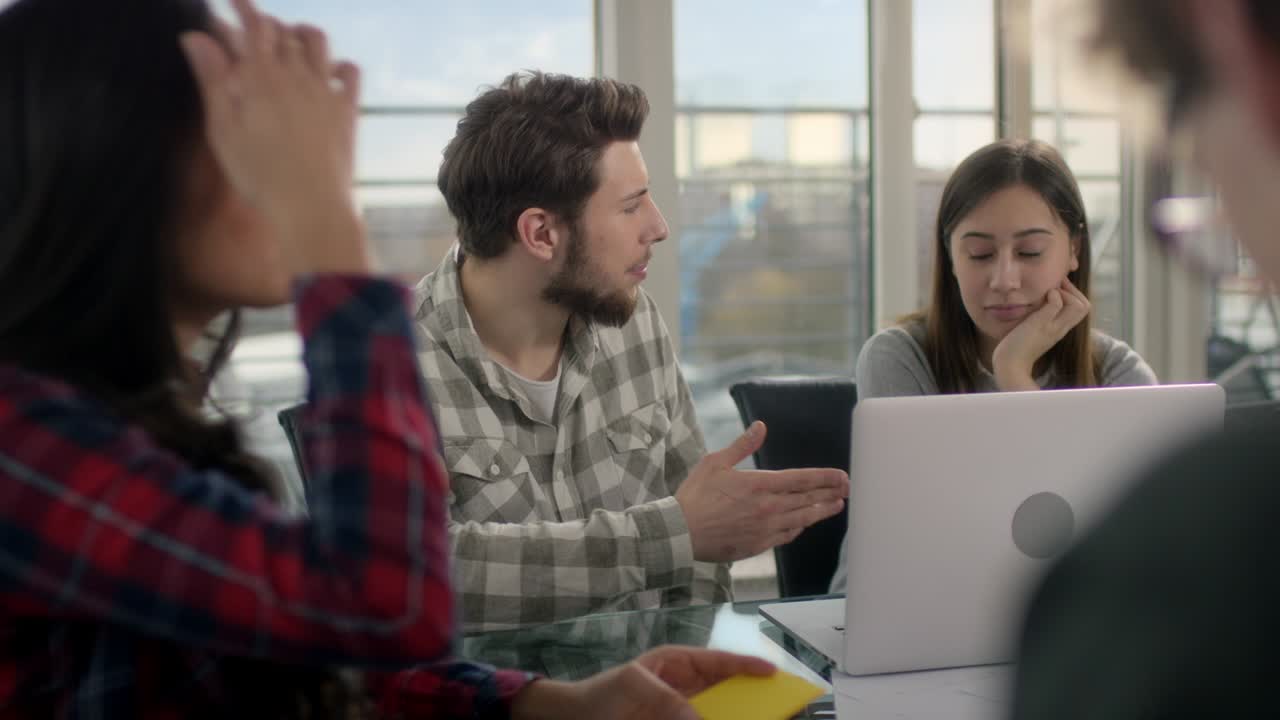 Collega che discute di lavoro sul portatile durante una riunione in sala conferenze.