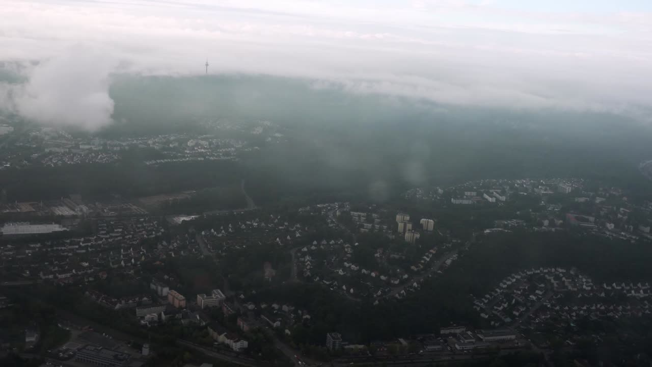 Low clouds blanket the rugged German mountains as the aircraft descends through the fog. A moody and cinematic approach shot capturing the beauty of overcast terrain before landing