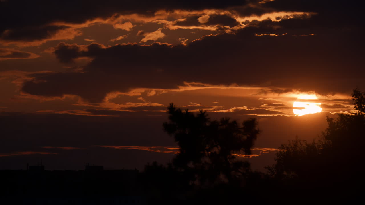 Atemberaubender Sonnenuntergang über dem Horizont, wobei Wolken einen dramatischen Himmel in einer friedlichen Landschaft erzeugen
