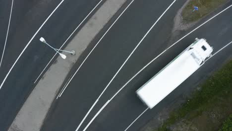Slow-top-down-aerial-pan-of-fast-moving-vehicles-entering-a-motorway-in-Finland-near-Helsinki