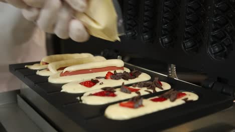 making waffle hot dogs with strawberries and chocolate