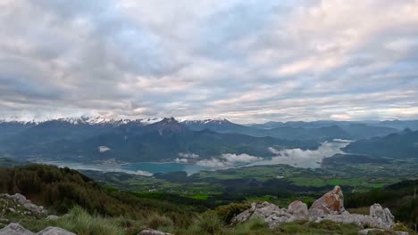 timelapse of clouds rolling through the snowy french alps with a glacier lake