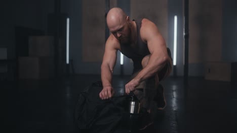 hombre empacando su bolsa de gimnasia después del entrenamiento