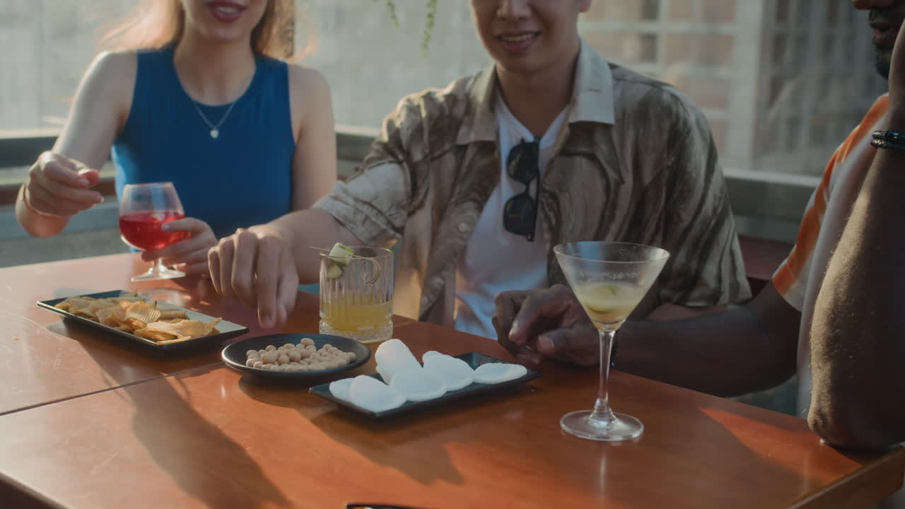 People Eating Snacks and Drinking Cocktails in Cafe