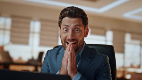 excited man winning achievement at cabinet closeup. happy boss face rejoicing