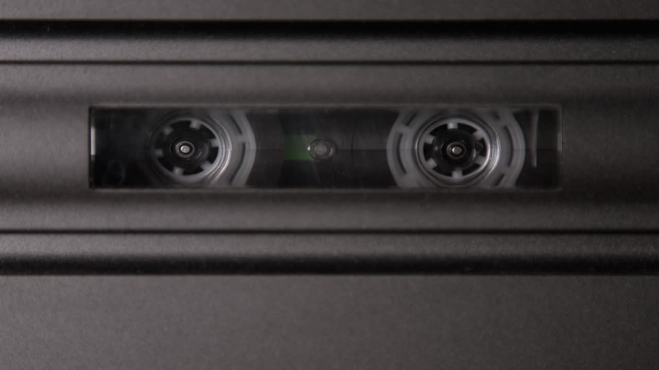 90년대 시대의 빈티지 테이프 데크에서 재생되는 컴 ⁇ 트 카세트의 영상