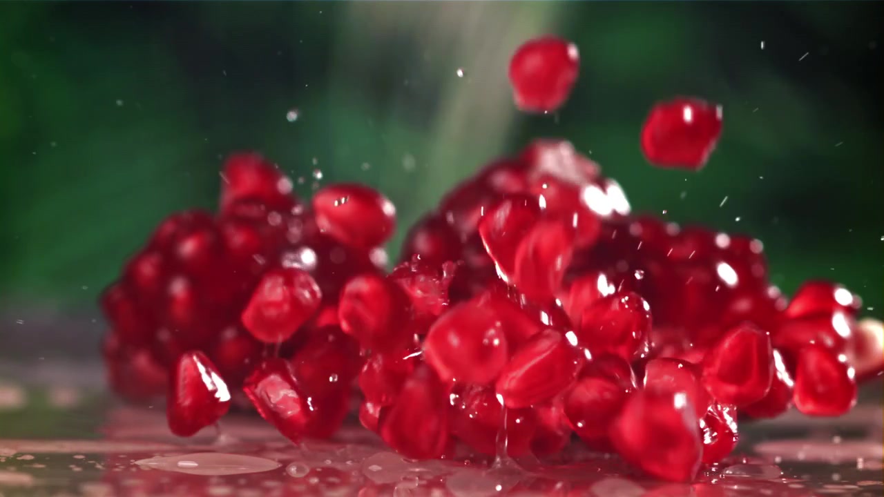 Friske røde granatæblekerner falder i slowmotion