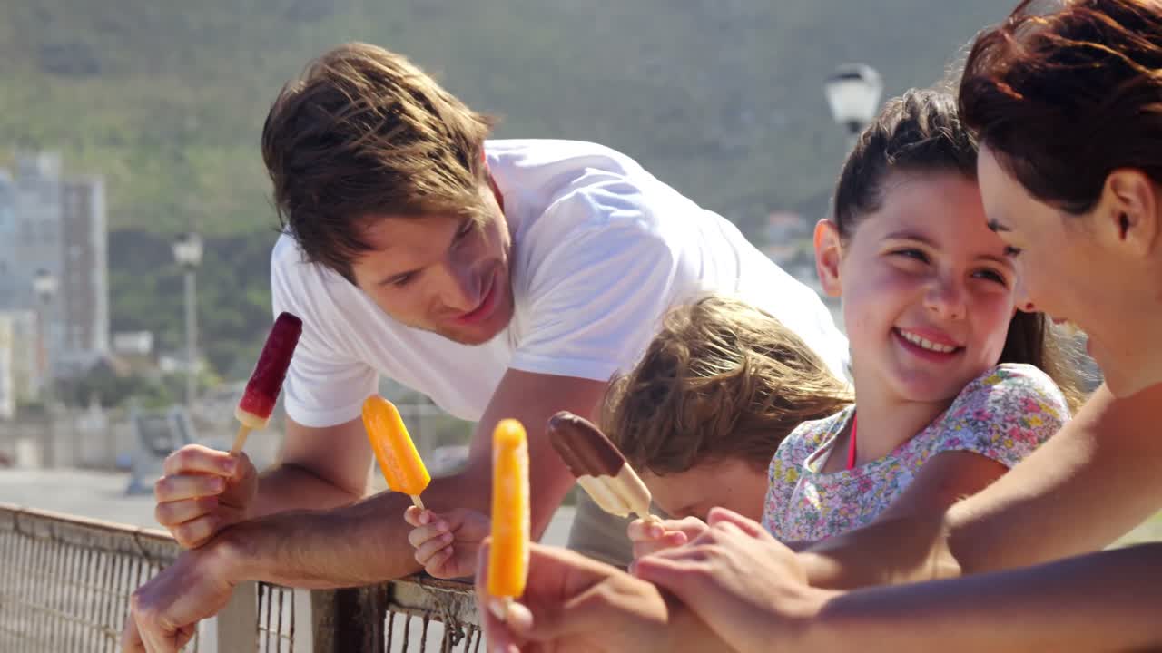 familia feliz comiendo helado en la playa