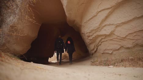 coppia che cammina attraverso i sentieri delle caverne esplorando il paesaggio della cappadocia in turchia