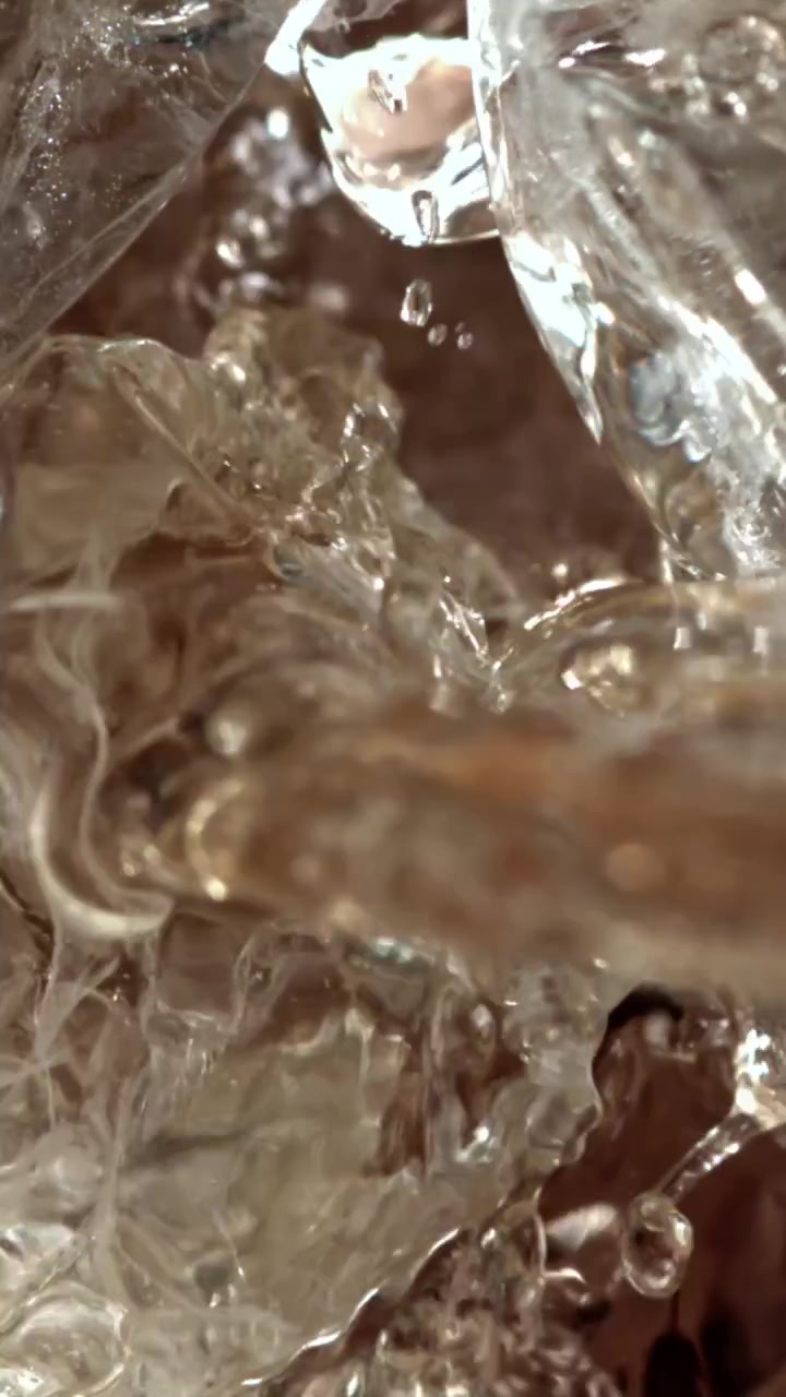 Macro di acqua che si versa su cubetti di ghiaccio