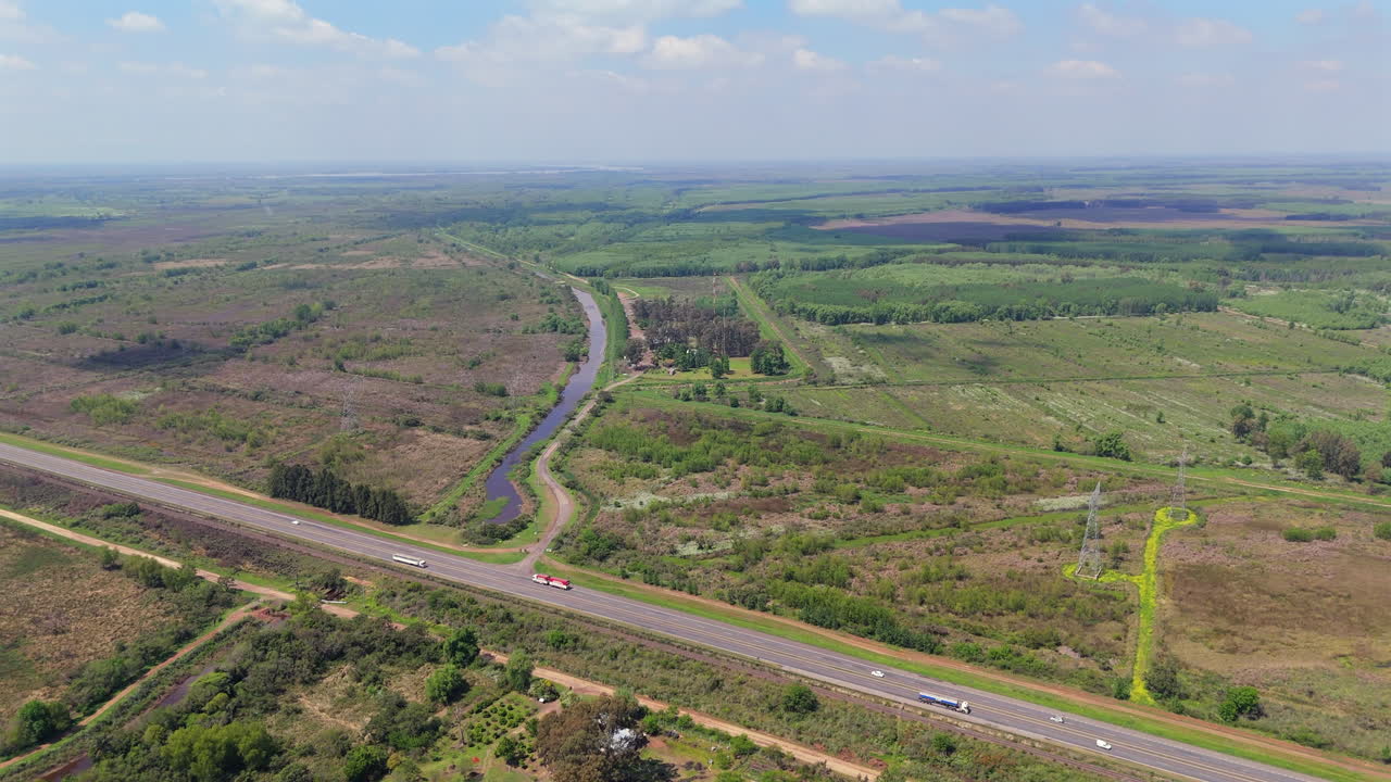 Panoramic view of highway through valley with industrial agricultural crops