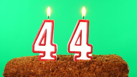 cake with the number 44 lighted candle. chroma key. green screen. isolated