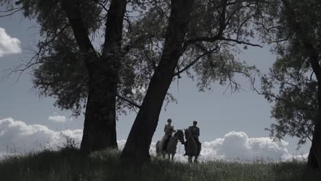 una pareja a caballo en un bosque.