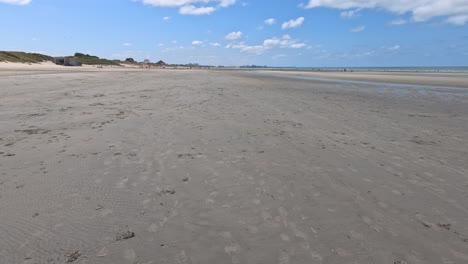 smooth forward camera movement over a wide, empty sandy beach in dunkirk, france