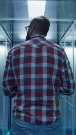 a man walking through a data center server room