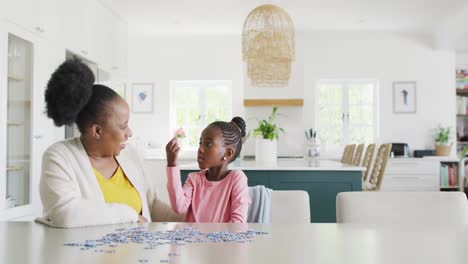 Feliz-Nieta-Y-Abuela-Afroamericana-Haciendo-Rompecabezas-En-Casa,-Copiando-Espacio