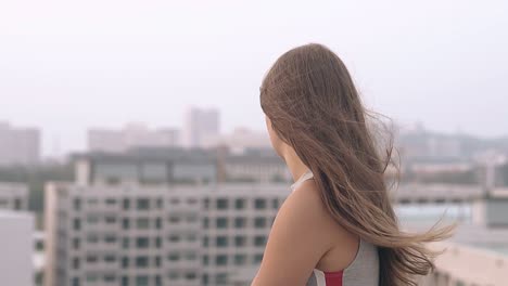 Señora-Con-El-Pelo-Ondeando-En-El-Viento-Se-Encuentra-En-El-Techo-A-Cámara-Lenta