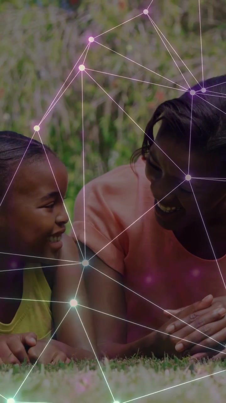 Vertical video: Child turning toward woman on grass, node network linking faces during tech bonding