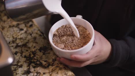 barista stirs hot chocolate with steamed milk