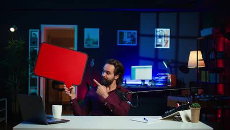 man arriving in studio, filming sponsored content, holding empty copy space sign