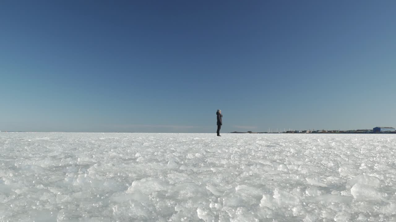 바다의 얼어붙은 표면에 서 있는 여성, 넓은 시야