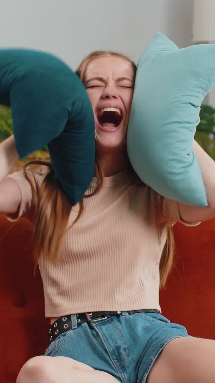 Repair work at neighbours concept irritated woman at home cover ears with pillows annoyed by noise