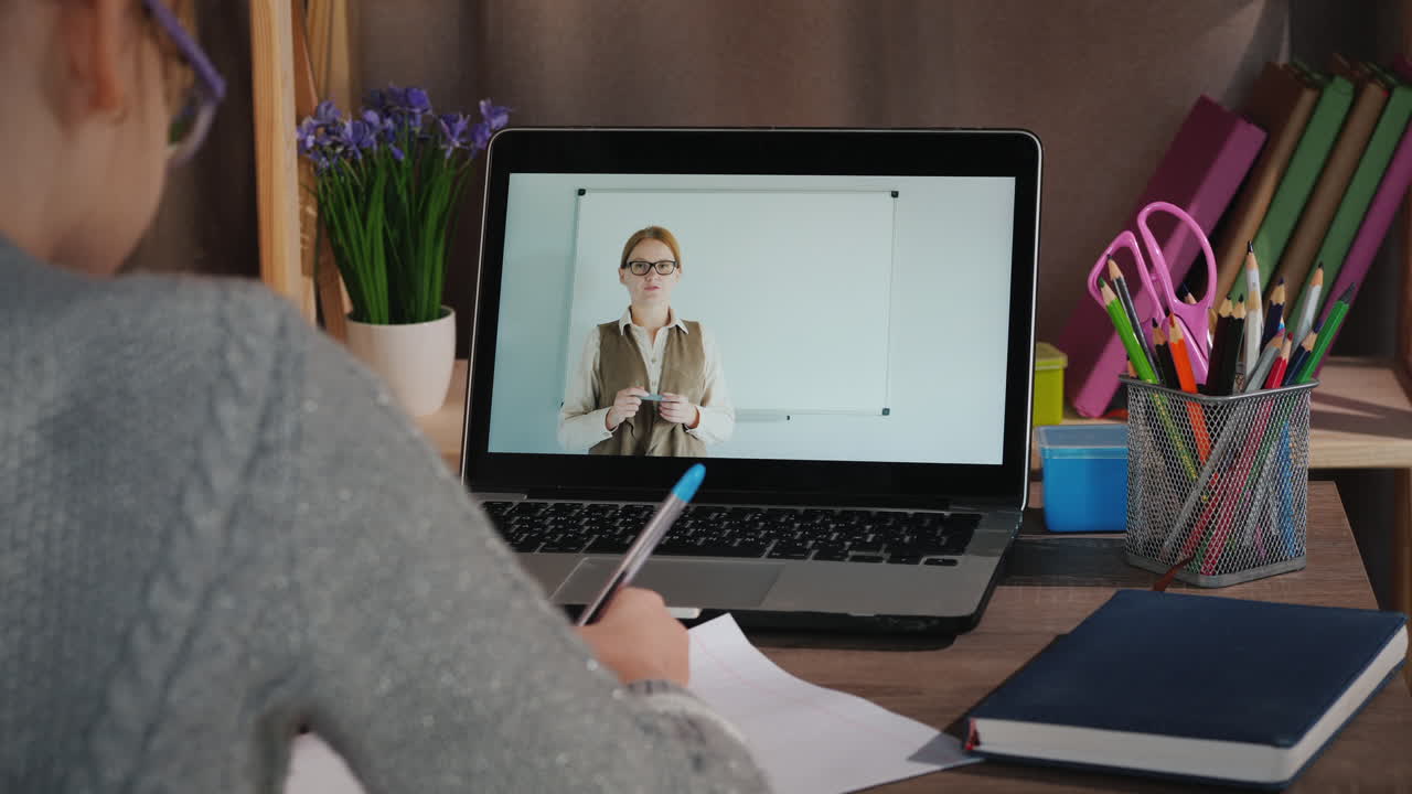 la niña aprende en casa en línea con su computadora portátil mientras su maestra le da una lección en la pantalla