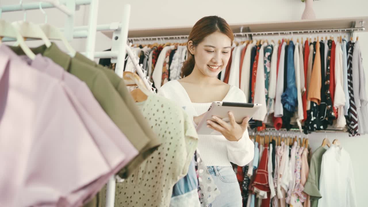 empresarios y propietarios de pequeñas empresas de tiendas de moda que utilizan tabletas digitales para comprobar el stock en las barandillas de las tiendas de ropa.