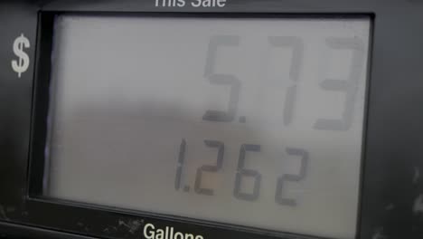 pantalla de la bomba de la gasolinera llenándose y bombeando lentamente de más de un galón a 8 dólares de combustible