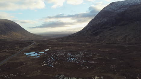 epic moving aerial shot of the hills and mountains at glencoe, scotland in great britain