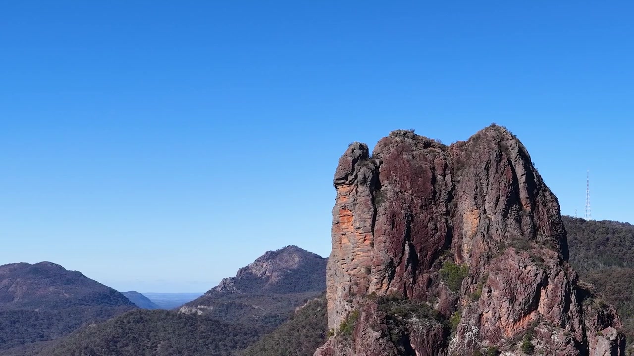 Toma panorámica estática del dique volcánico Breadknife bajo un cielo azul claro en Australia