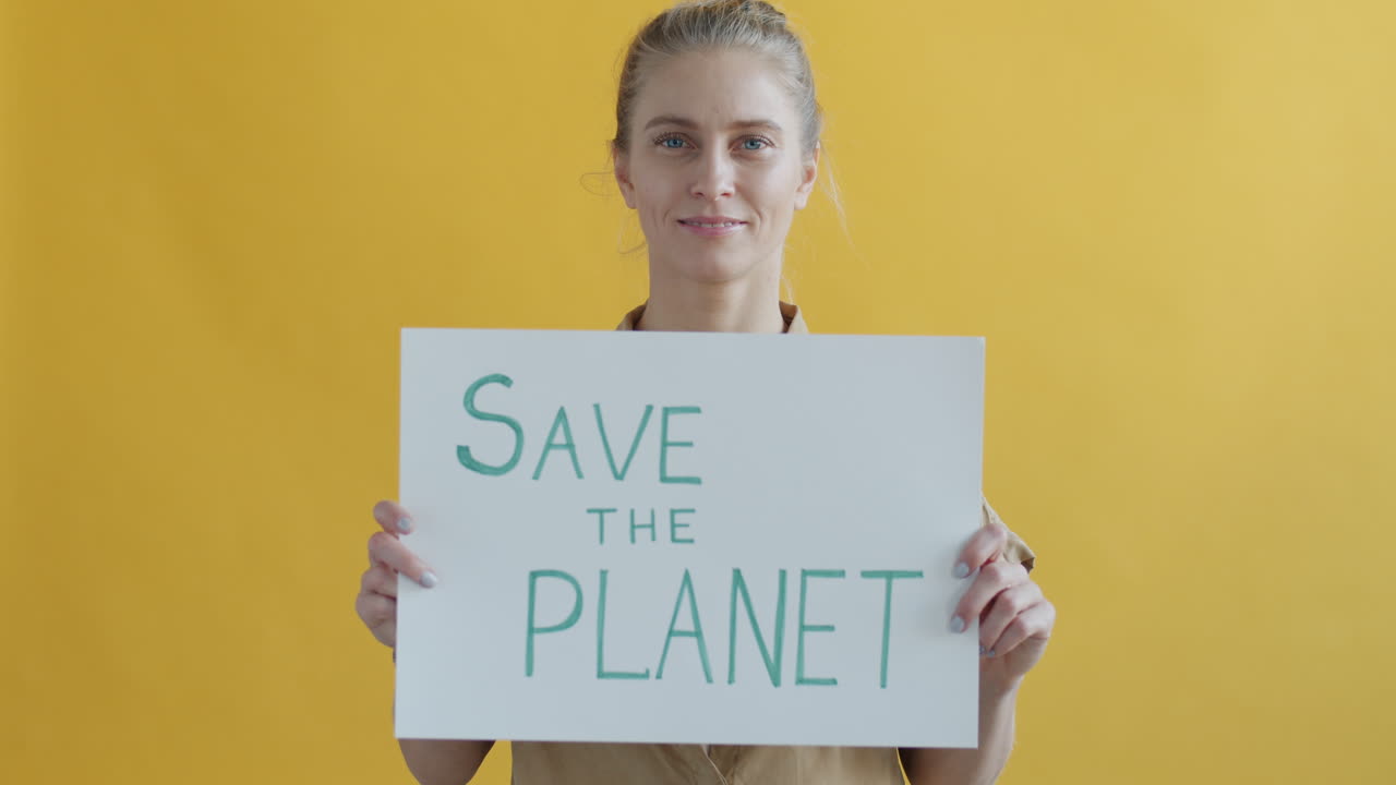Woman Holding a Sign that Says "Save the Planet"
