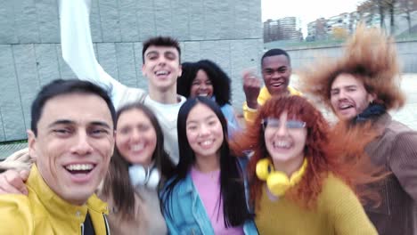 excited group of multi-ethnic celebrating and taking a selfie outdoors