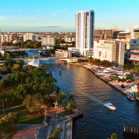 motor boats are on the narrow river in the city downtown. beautiful view of sunny miami panorama, florida, usa.