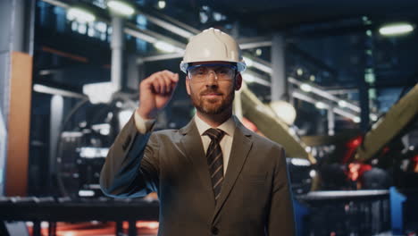 especialista en fabricación confiado posando en la instalación de producción de cerca.