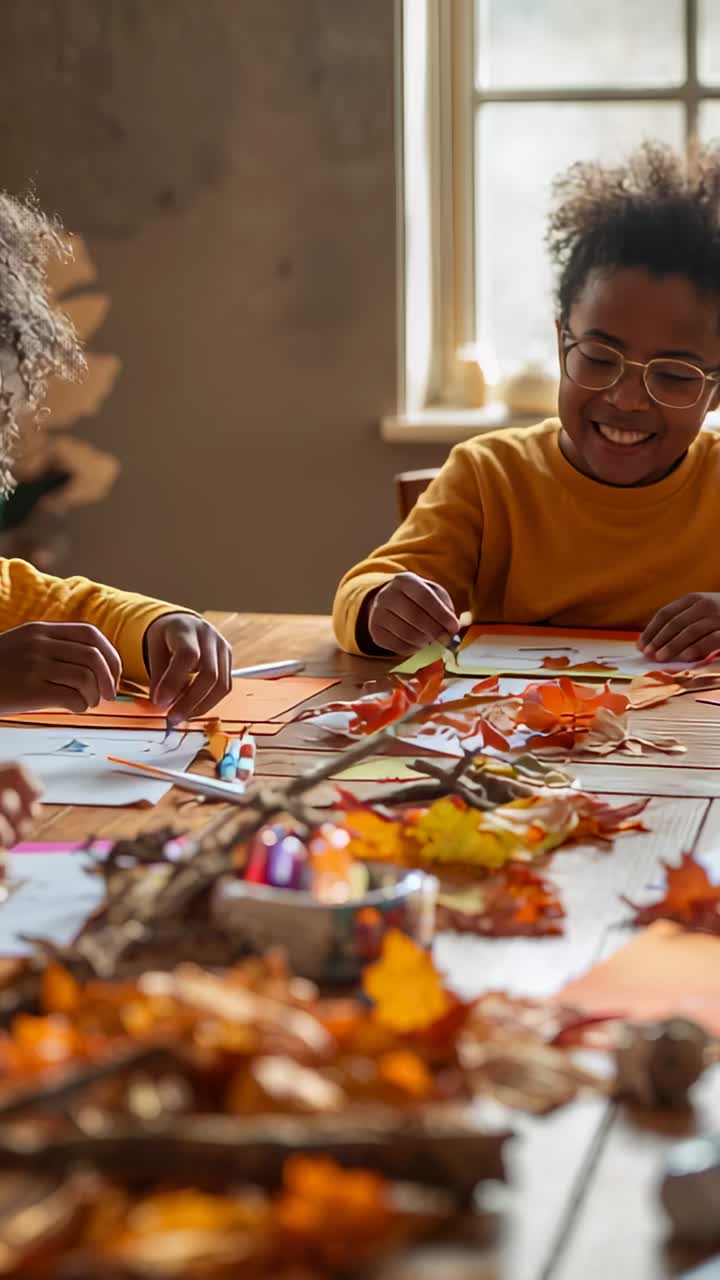 Vertical video: Reaching boy in specs mustard top placing leaves on table at window, making collage
