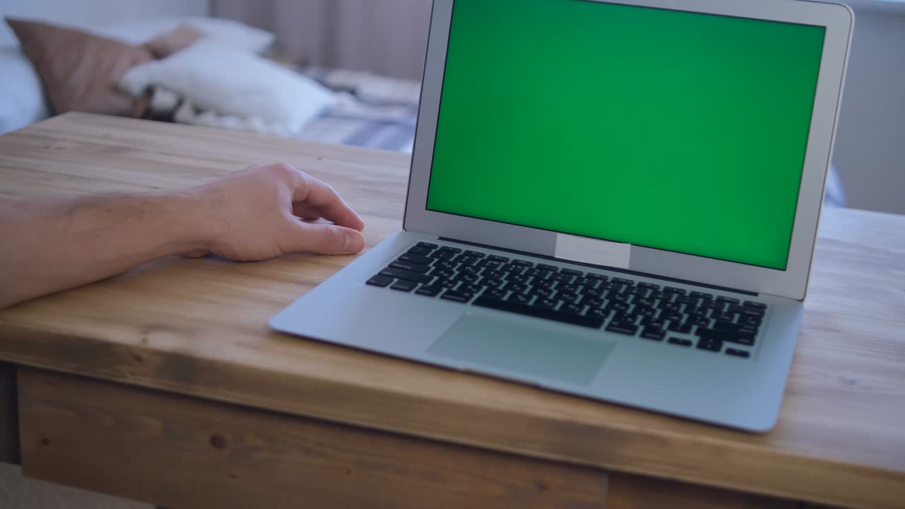 L'uomo lavora da remoto. Schermo verde del laptop. Messa a fuoco selettiva e morbida. Il concetto di istruzione a distanza. Navigazione in Internet