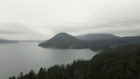 misty gray skies touch the tops of peaks on orcas island, washington, aerial panorama
