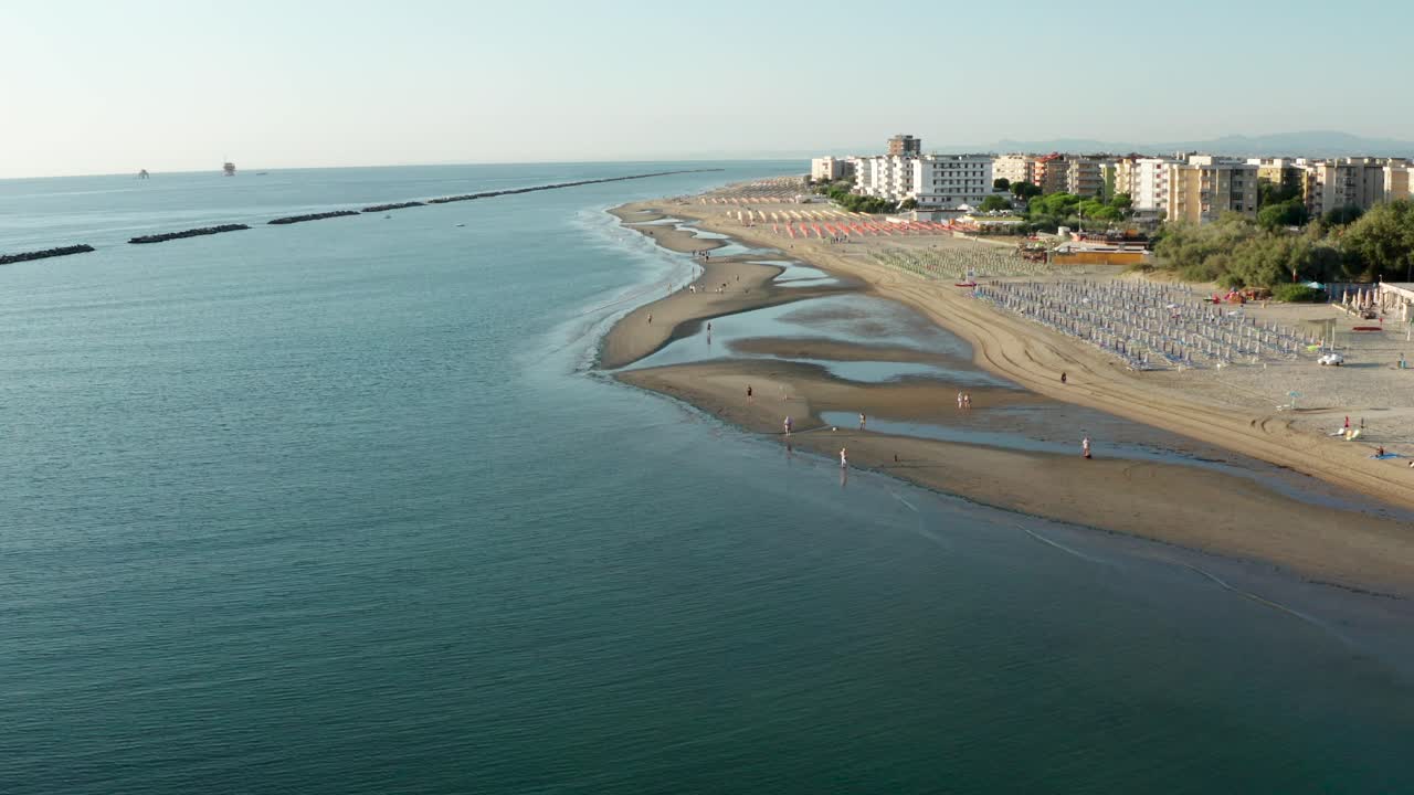 toma aérea de playa de arena con sombrillas y miradores