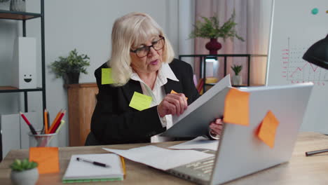 tired exhausted senior business woman office manager with laptop sticky notes sticks with many tasks