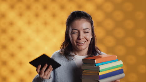 Woman-debating-between-physical-books-and-ebooks-on-ereader,-studio-background