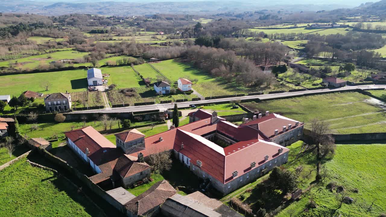 la órbita aérea muestra el monasterio y los campos agrícolas en ourense, galicia, españa.