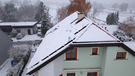 solar panels on house roof covered by snow in winter