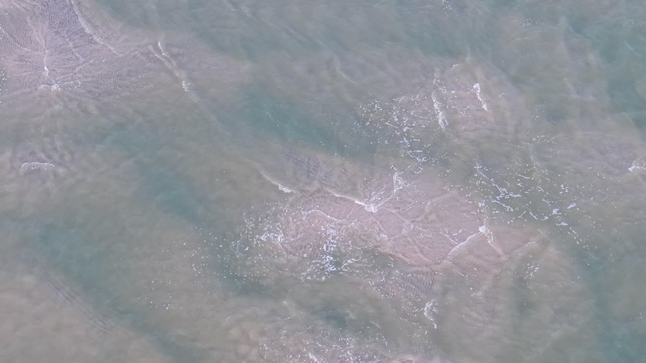 Vista aerea dall'alto delle correnti d'acqua vorticose con motivi di schiuma sulla superficie a Charleston, Carolina del Sud